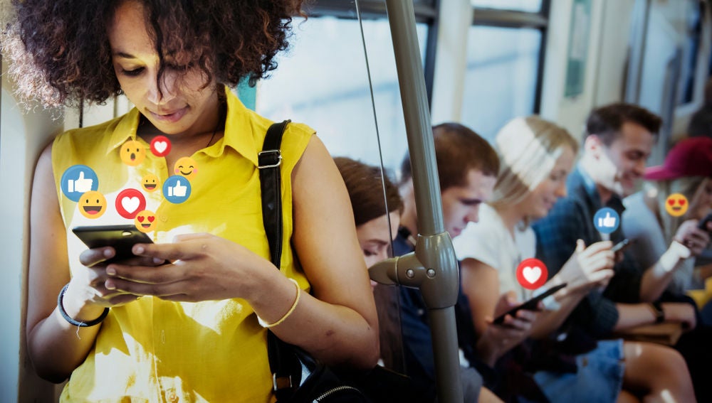 Una joven participa en redes sociales mientras viaja en el metro