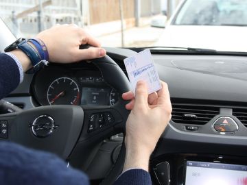 Foto de archivo: Un hombre sostiene un carnet de conducir 