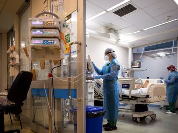 Enfermeras atienden a un paciente covid-19 en una habitación de hospital