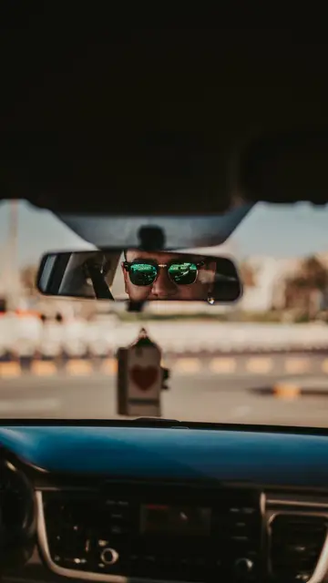 Conductor reflejado en el espejo retrovisor Conductor reflejado en el espejo retrovisor