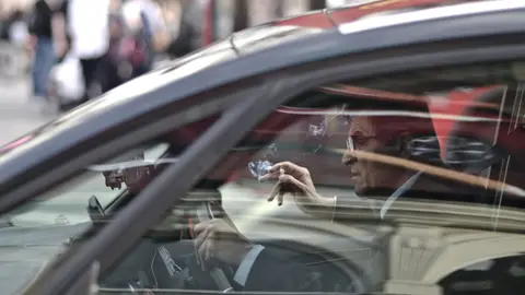 Conductor fumando al volante Conductor fumando al volante