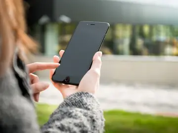 Imagen de archivo de una mujer usando un teléfono móvil. Imagen de archivo de una mujer usando un teléfono móvil.
