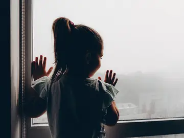 Niña asomada a la ventana Niña asomada a la ventana