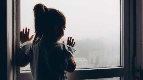 Niña asomada a la ventana