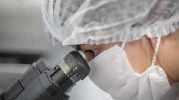 Cient&iacute;fica mira a trav&eacute;s de un microscopio en un laboratorio