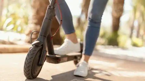 Mujer circulando en un patinete eléctrico Mujer circulando en un patinete eléctrico