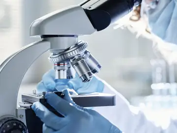 Científico mirando por un microscopio Científico mirando por un microscopio