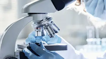 Científico mirando por un microscopio Científico mirando por un microscopio