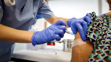 Una señora vacunándose contra la gripe y la COVID Una señora vacunándose contra la gripe y la COVID