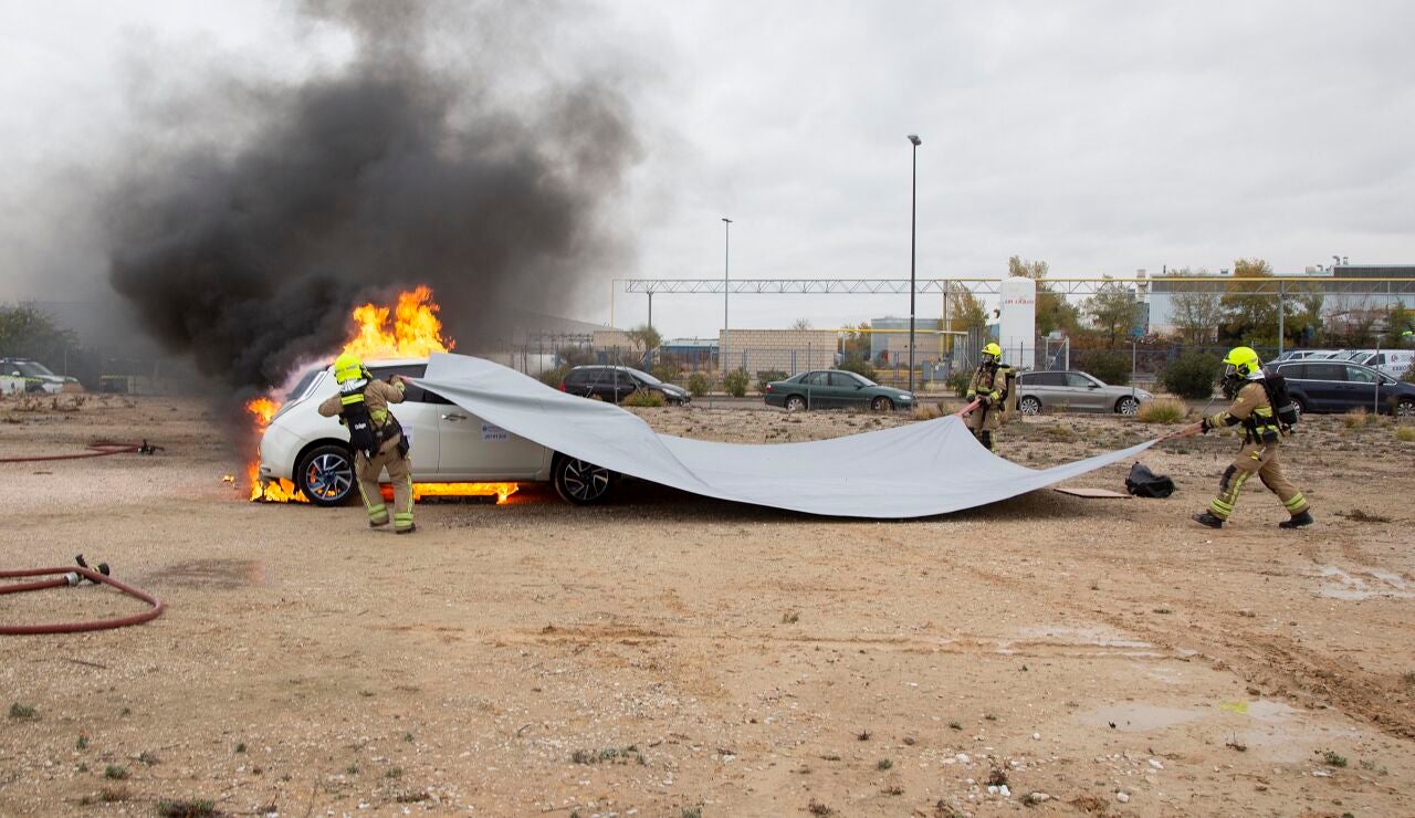 Prueba de extinci&oacute;n de fuego en un coche el&eacute;ctrico con una manta ign&iacute;fuga