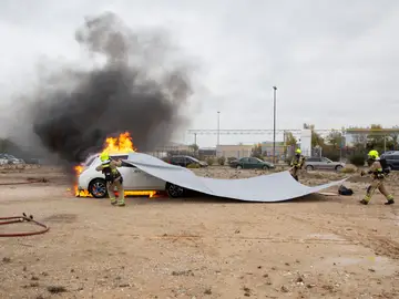 Prueba de extinción de fuego en un coche eléctrico con una manta ignífuga Prueba de extinción de fuego en un coche eléctrico con una manta ignífuga