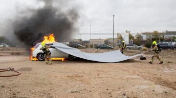 Prueba de extinci&oacute;n de fuego en un coche el&eacute;ctrico con una manta ign&iacute;fuga