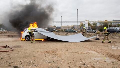 Prueba de extinci&oacute;n de fuego en un coche el&eacute;ctrico con una manta ign&iacute;fuga